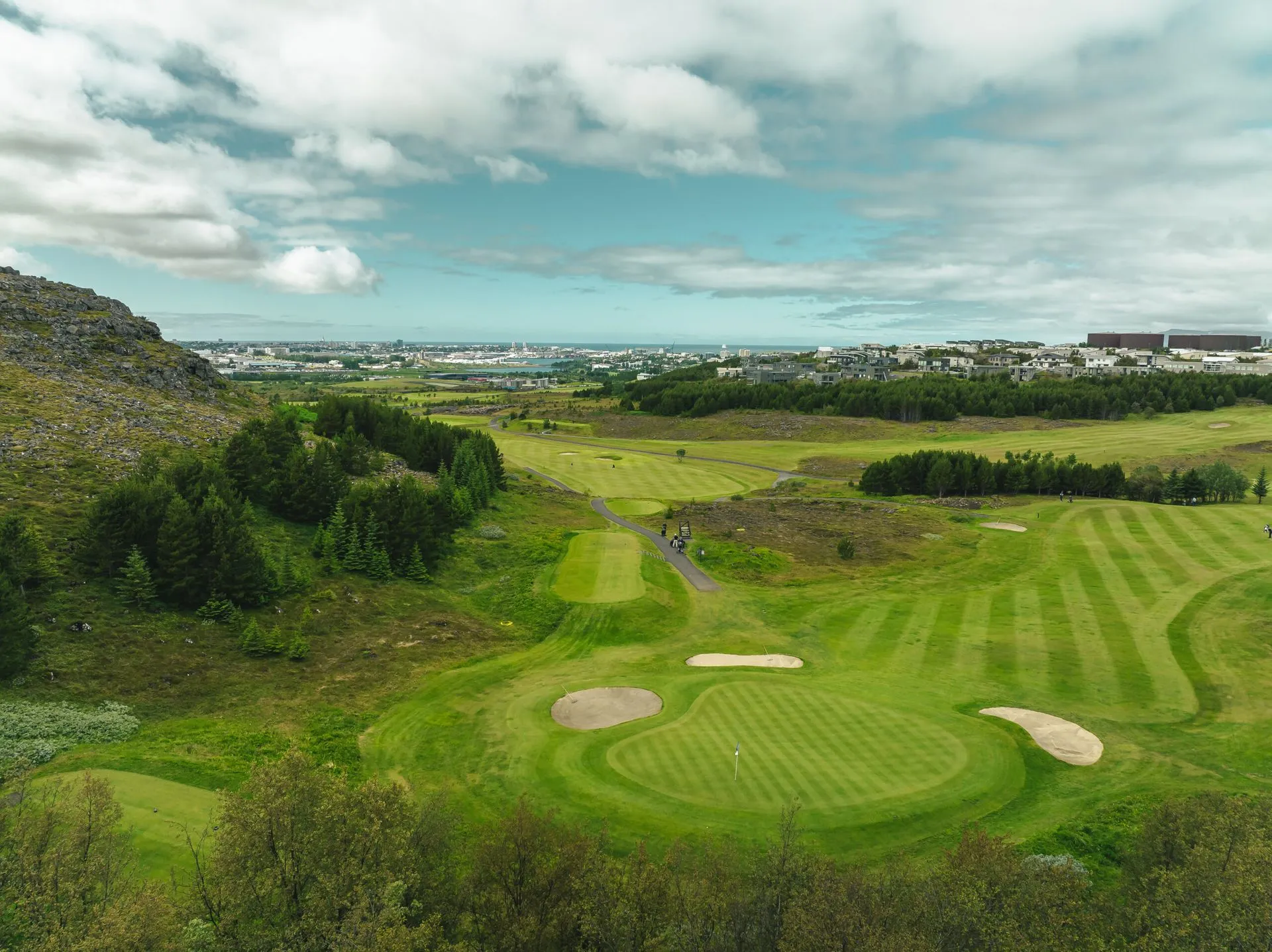Elevated green at Grafarholt with Reykjav&iacute;k and the ocean in the background