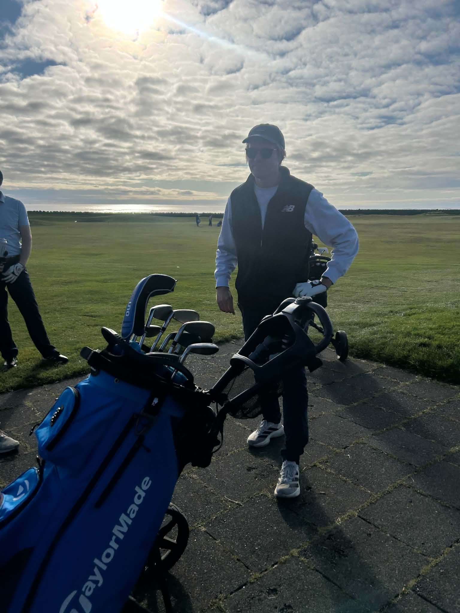 Stefán with his golf bag on the course